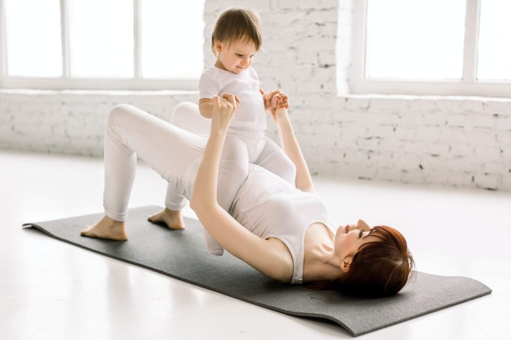 Mother working out, doing butt bridge exercise, wearing white sportswear