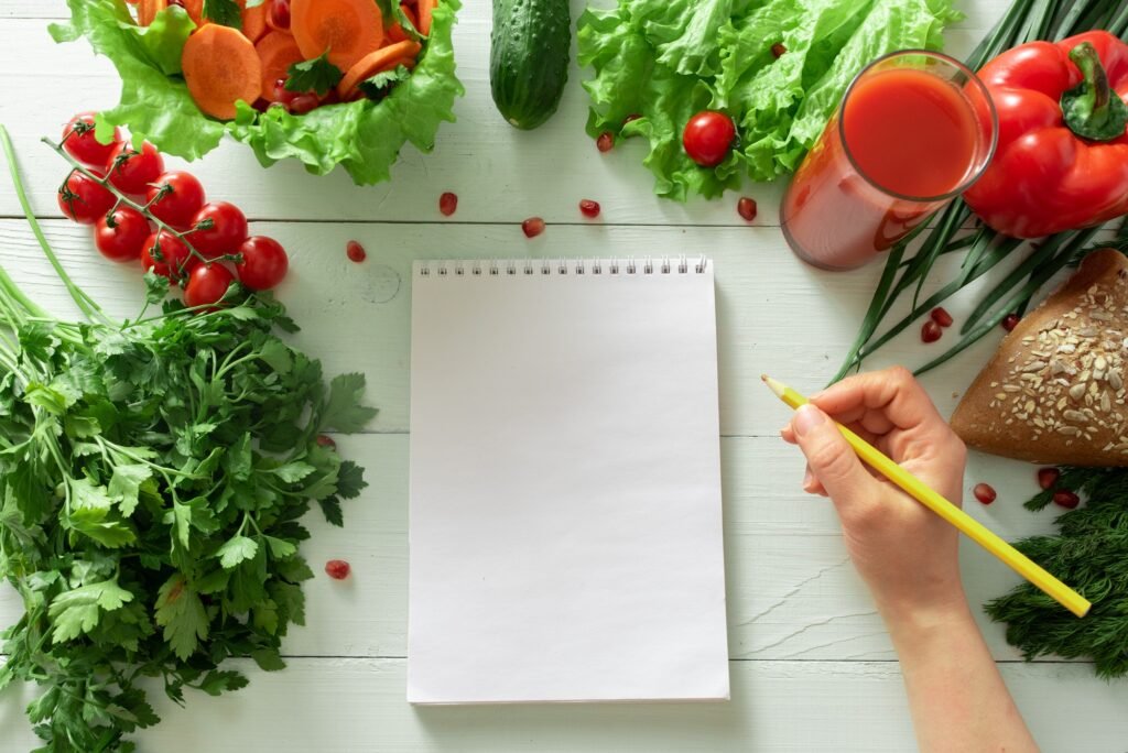 Notebook for keeping a diary of weight loss on the background of vegetables.
