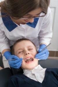 Female dentist examines the teeth of the patient child