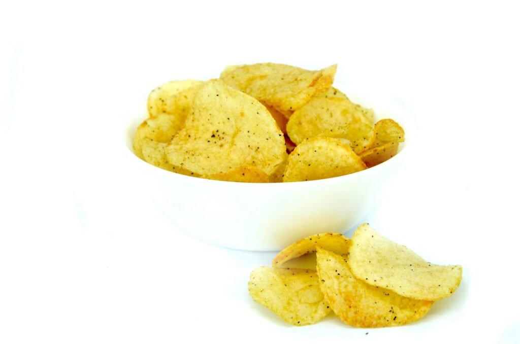 a white bowl filled with chips on top of a white table