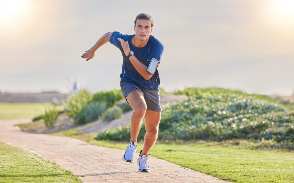 Fitness, runner in park and man running for cardio, action and energy outdoor, health and wellness