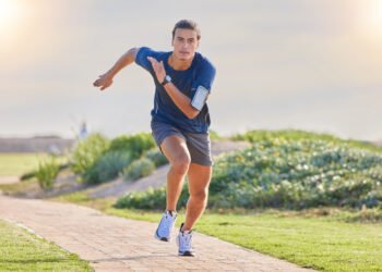 Fitness, runner in park and man running for cardio, action and energy outdoor, health and wellness