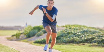 Fitness, runner in park and man running for cardio, action and energy outdoor, health and wellness