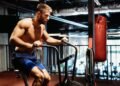 Man with weight training equipment exercising in sport gym club