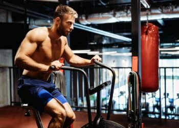 Man with weight training equipment exercising in sport gym club