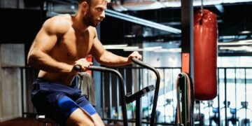 Man with weight training equipment exercising in sport gym club