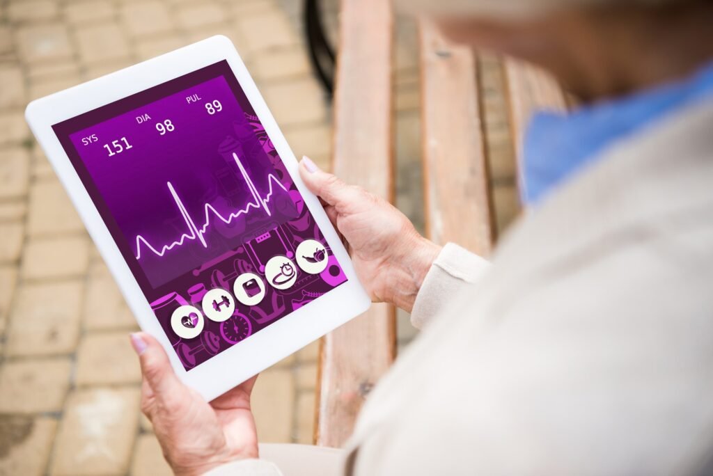 selective focus of senior woman holding digital tablet with heartbeat rate on screen