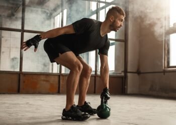 Sportsman working out with kettlebell in gym