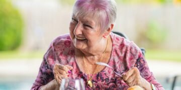 woman in purple and pink floral long sleeve shirt sitting on chair